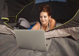 Hiker in tent using laptop. Photo : Mike Kemp