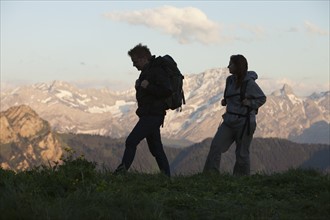 Switzerland, Leysin, Hikers marching through Alpine landscape. Photo: Mike Kemp