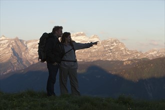 Switzerland, Leysin, Hikers looking at view of Alps. Photo : Mike Kemp