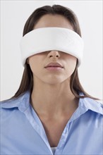 Studio shot of woman wearing blindfold. Photo : Jan Scherders