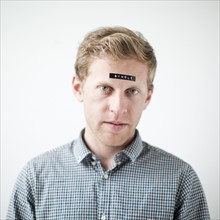 Studio shot of young man with word 'single' on forehead. Photo: Jessica Peterson
