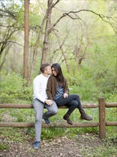 Young couple sitting on fence. Photo : Jessica Peterson