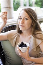 Portrait of young woman having blackberries. Photo : Jessica Peterson
