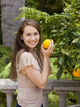 Portrait of young woman with orange. Photo : Jessica Peterson