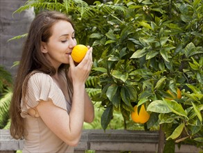 Young woman smelling orange. Photo : Jessica Peterson