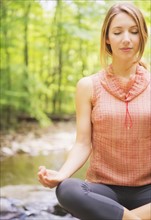 Woman practicing joga in forest. Photo: Tetra Images