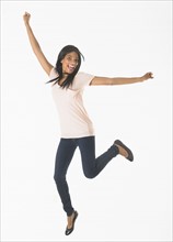 Portrait of woman jumping, studio shot.