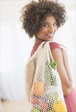 Portrait of woman carrying grocery bag.