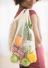 Woman carrying grocery bag.