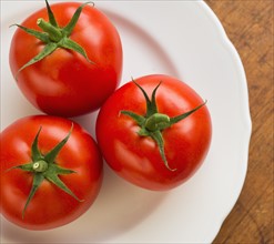 Tomatoes on plate, studio shot.