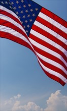 US flag against blue sky.