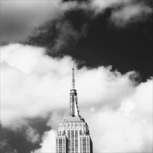 Empire State Building under cloudy sky.