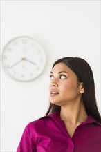 Woman looking at clock on wall.