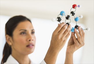 Female scientist holding molecule model.