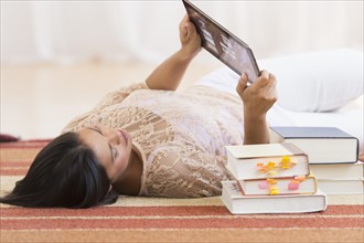 Woman lying on floor and using tablet PC.