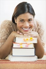 Portrait of female student leaning on books.