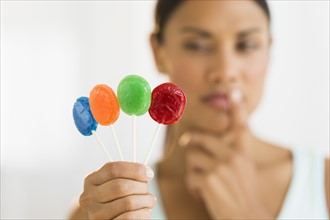 Woman holding colorful lollypops.
