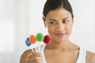 Woman holding colorful lollypops.
