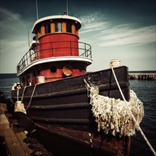Tugboat moored at pier.