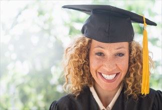 Portrait of smiling young woman in mortarboard.