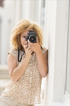 Portrait of young woman photographing.