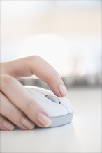 Close up of woman's hands using computer mouse.