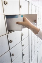 Woman taking letters from safety deposit box.