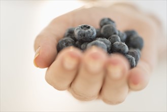 Blueberries on woman's hand.