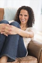 Portrait of woman sitting in living room.