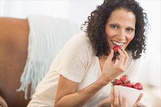 Portrait of woman eating strawberries.
