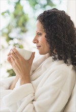 Woman relaxing with cup of coffee.