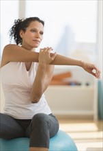 Portrait of woman stretching on exercise ball.