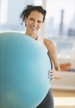 Portrait of woman exercising with exercise ball.