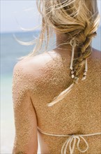 Woman's back with sticking sand . Photo : Jamie Grill