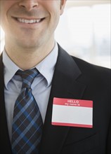 Office worker with name tag on suit. Photo : Jamie Grill