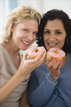 Female friends eating donuts. Photo: Jamie Grill