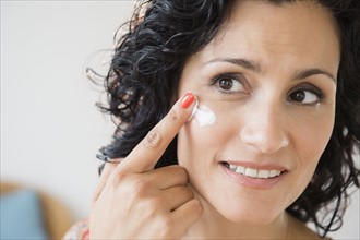 Mature woman applying anti-ageing cream. Photo: Jamie Grill