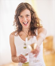Woman holding wine bottle and glass. Photo : Daniel Grill