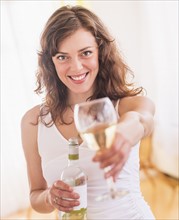 Woman holding wine bottle and glass. Photo : Daniel Grill