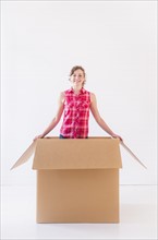 Studio shot of young woman inside box. Photo : Daniel Grill