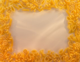 Variety of yellow pasta with blank white space in middle. Photo : Daniel Grill