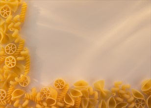 Variety of yellow pasta with blank white space in upper right corner. Photo : Daniel Grill