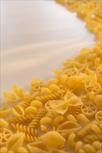 Variety of yellow pasta with blank white space in upper left corner. Photo : Daniel Grill