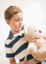 Boy (6-7) hugging his teddy-bear. Photo: Daniel Grill