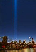View over Hudson River towards Manhattan with September 11th memorial lights and Brooklyn Bridge.