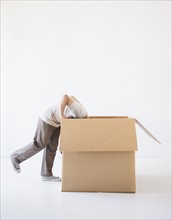 Man hiding inside cardboard box. Photo : Daniel Grill