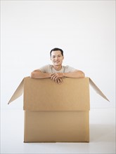Man sitting in cardboard box. Photo : Daniel Grill
