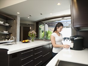 Young woman making morning coffee.