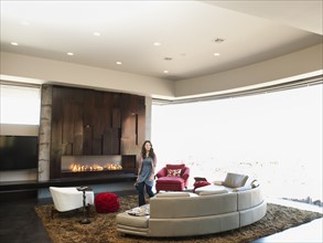 Young woman bustling in modern living room. Photo: Erik Isakson