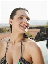 Young attractive woman standing on edge of swimming pool.